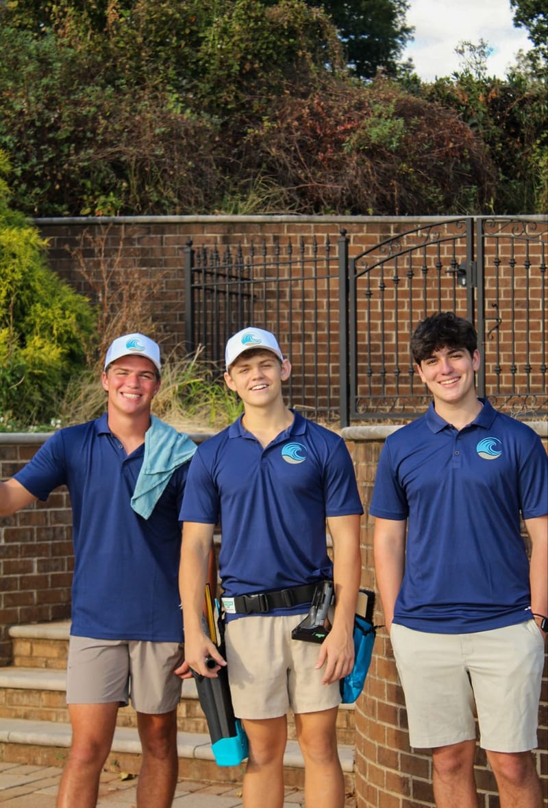 Three Cove Cleaning technicians in branded navy polos and caps