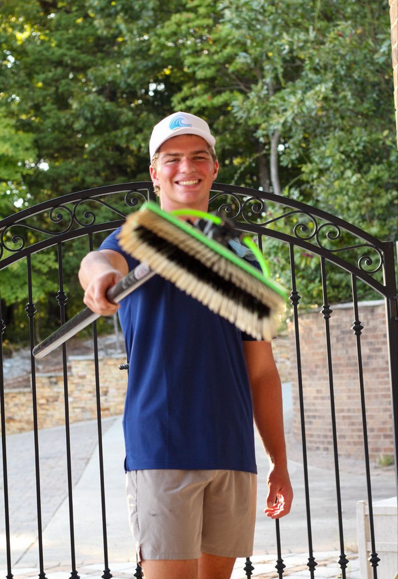 Smiling Cove Cleaning technician holding out a scrub brush